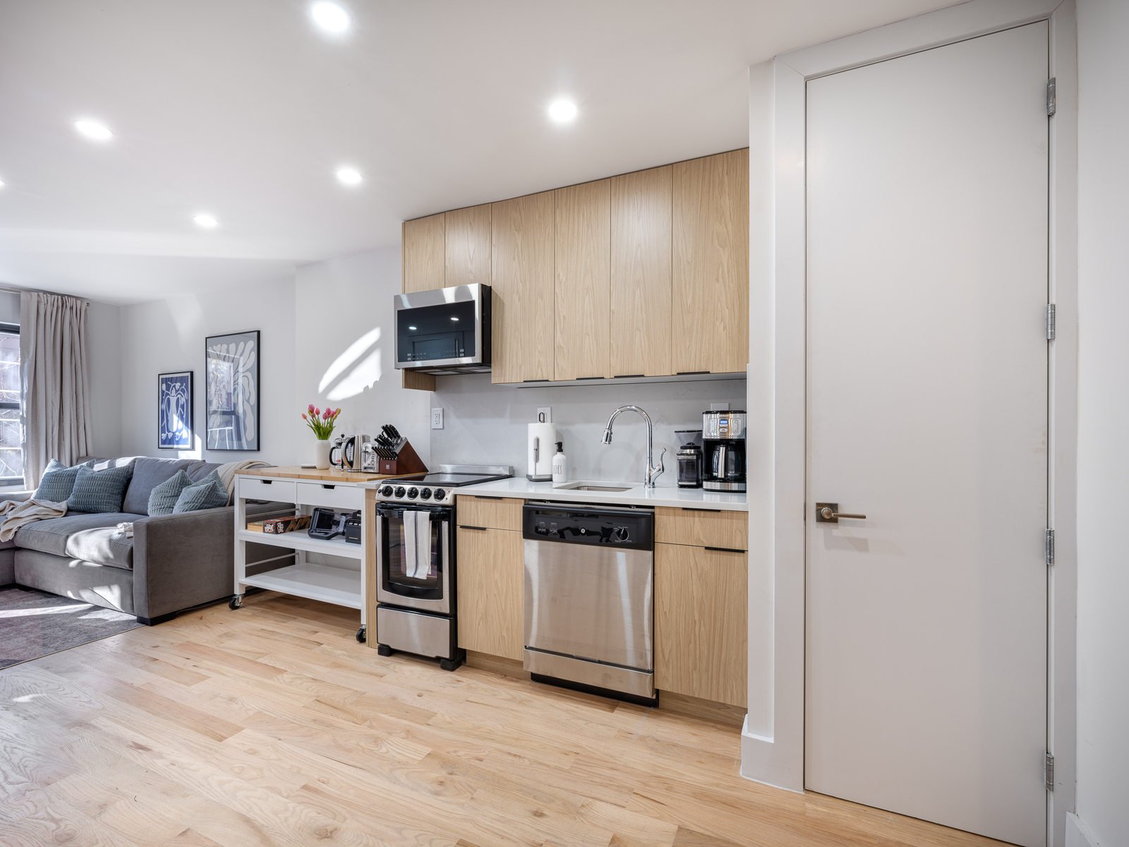 Light oak kitchen with stainless appliances and quartz counters